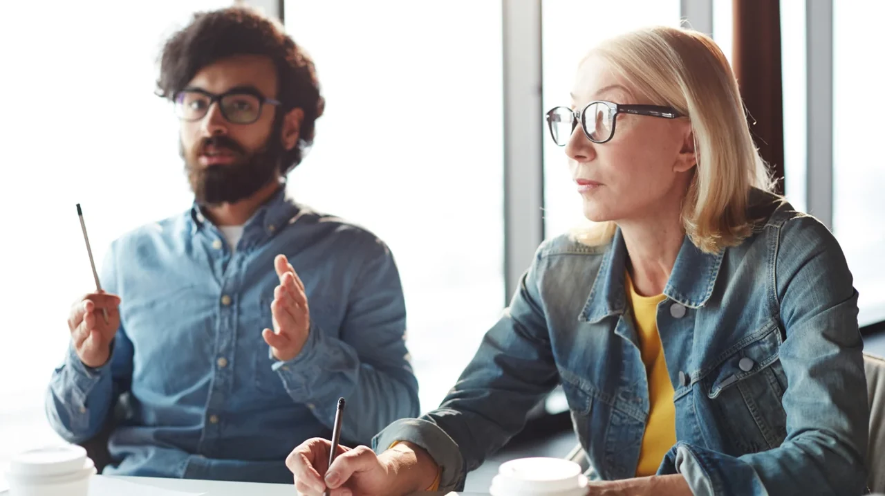 Two colleagues listening during a meeting.