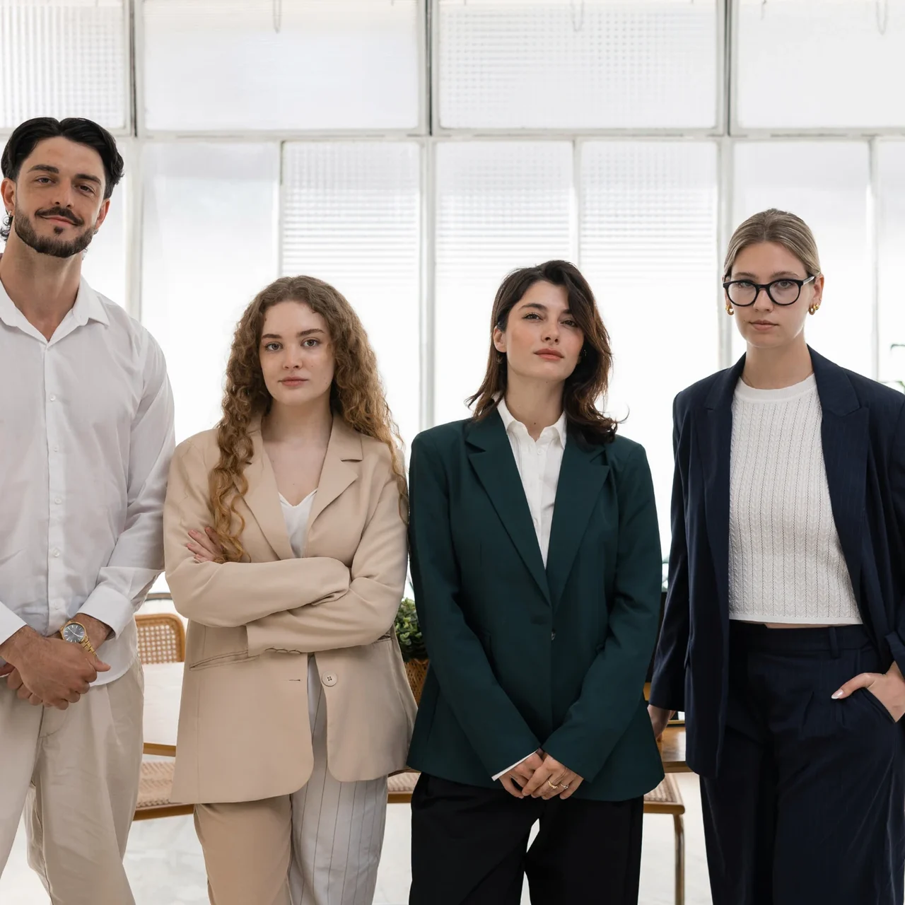 Four colleagues standing in a bright office.