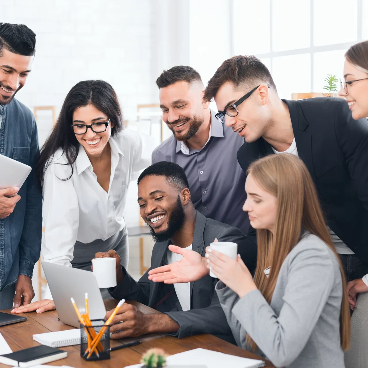 A team gathered around a laptop.