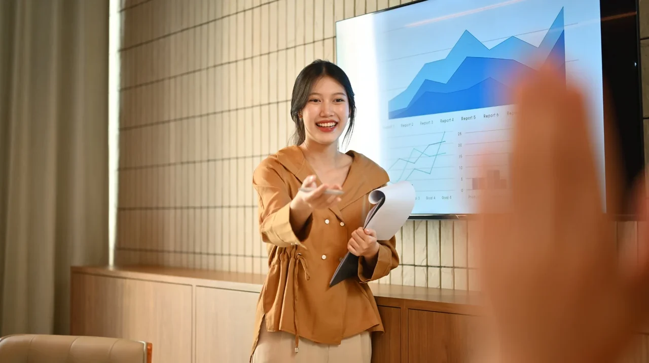 Professional presenting a chart on a screen.