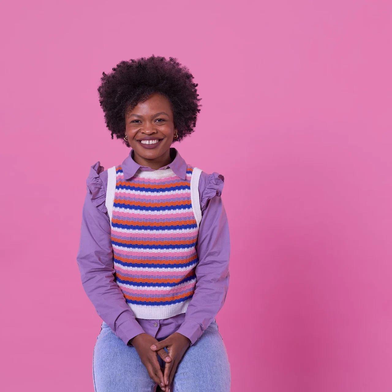 Smiling student against a pink background.