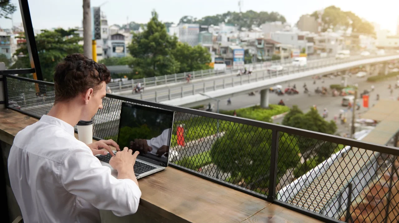 Professional working on a laptop at an outdoor table.