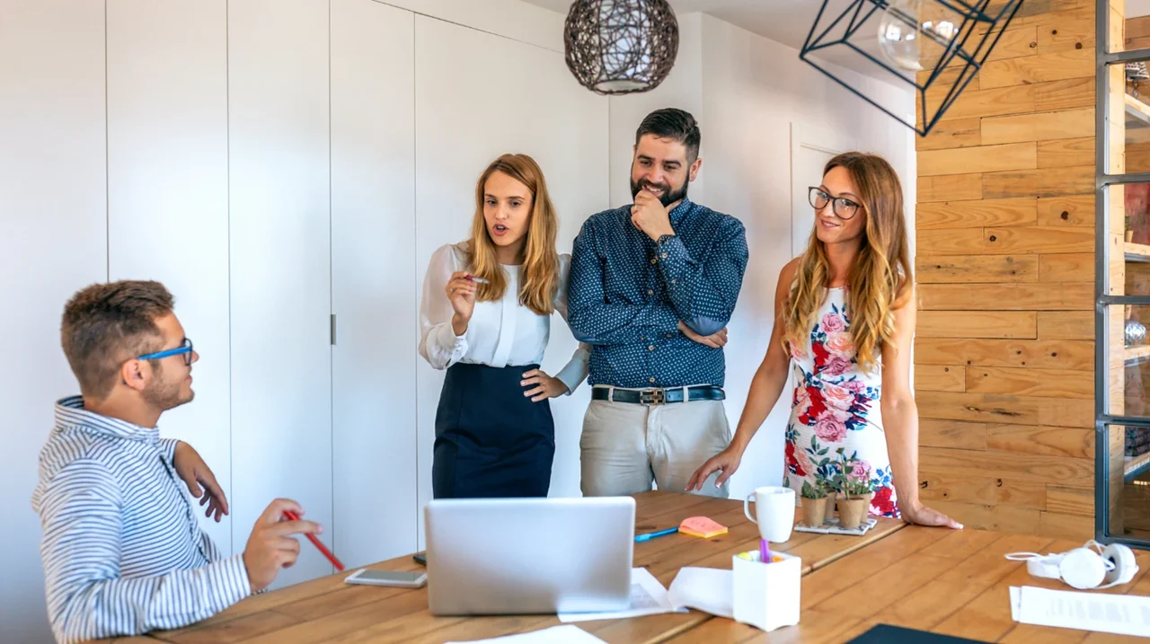 Colleagues discussing work in a creative workspace.