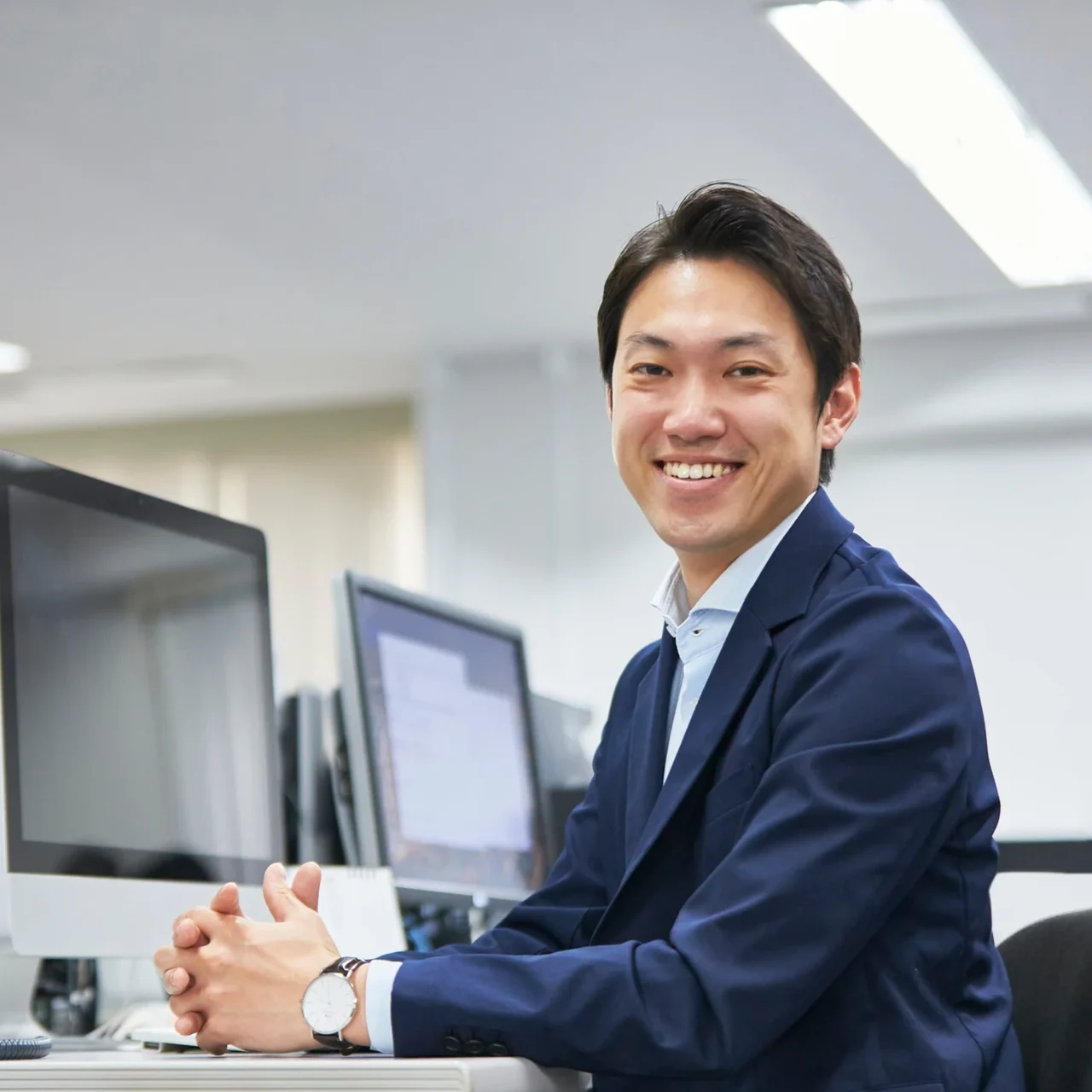 Professional smiling at a desk.