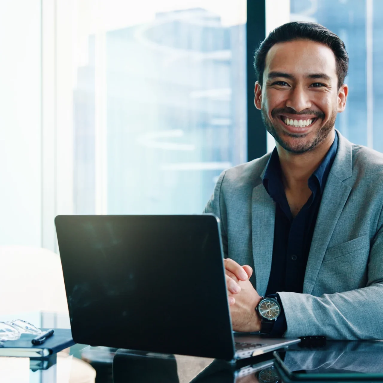 Smiling professional working at a laptop in a bright office.