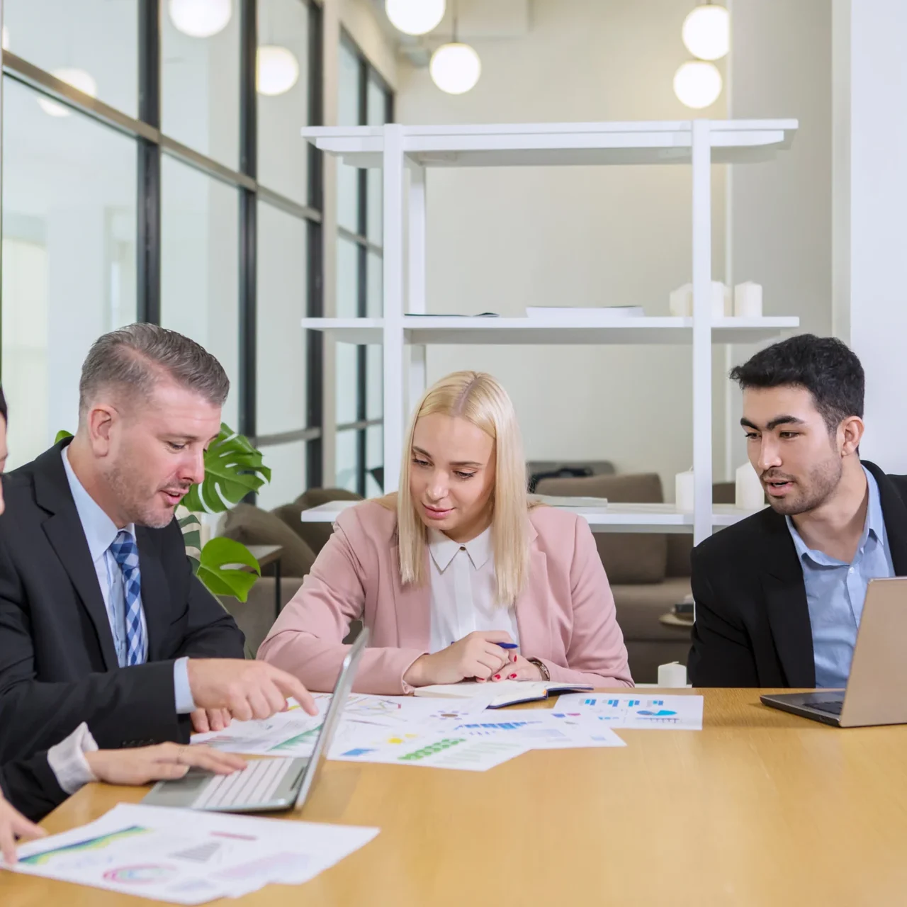 Three colleagues reviewing printed work.