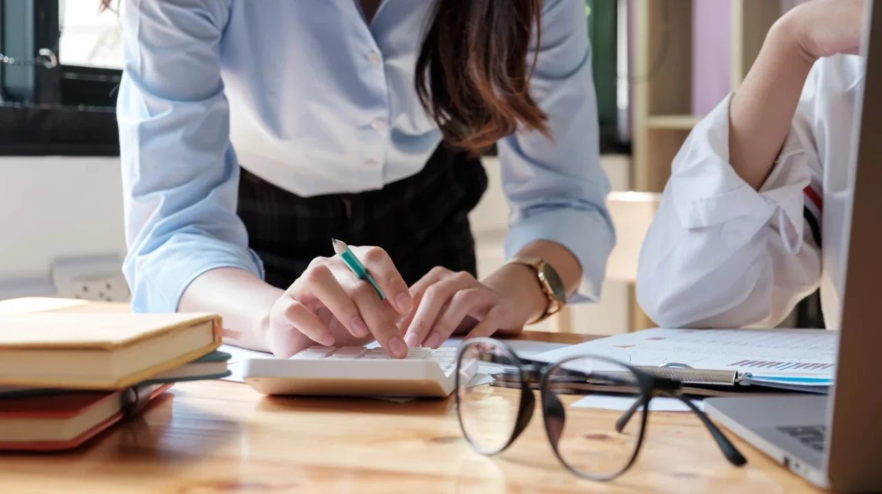 Colleagues reviewing notes and documents at a desk.