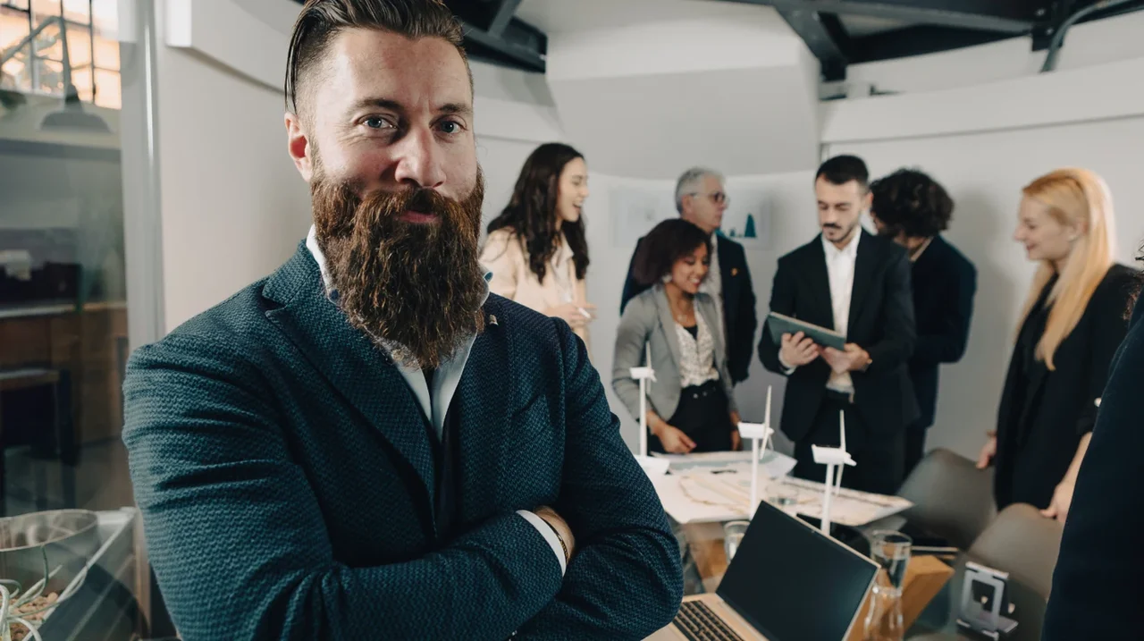 Professional standing in a busy collaborative workspace.