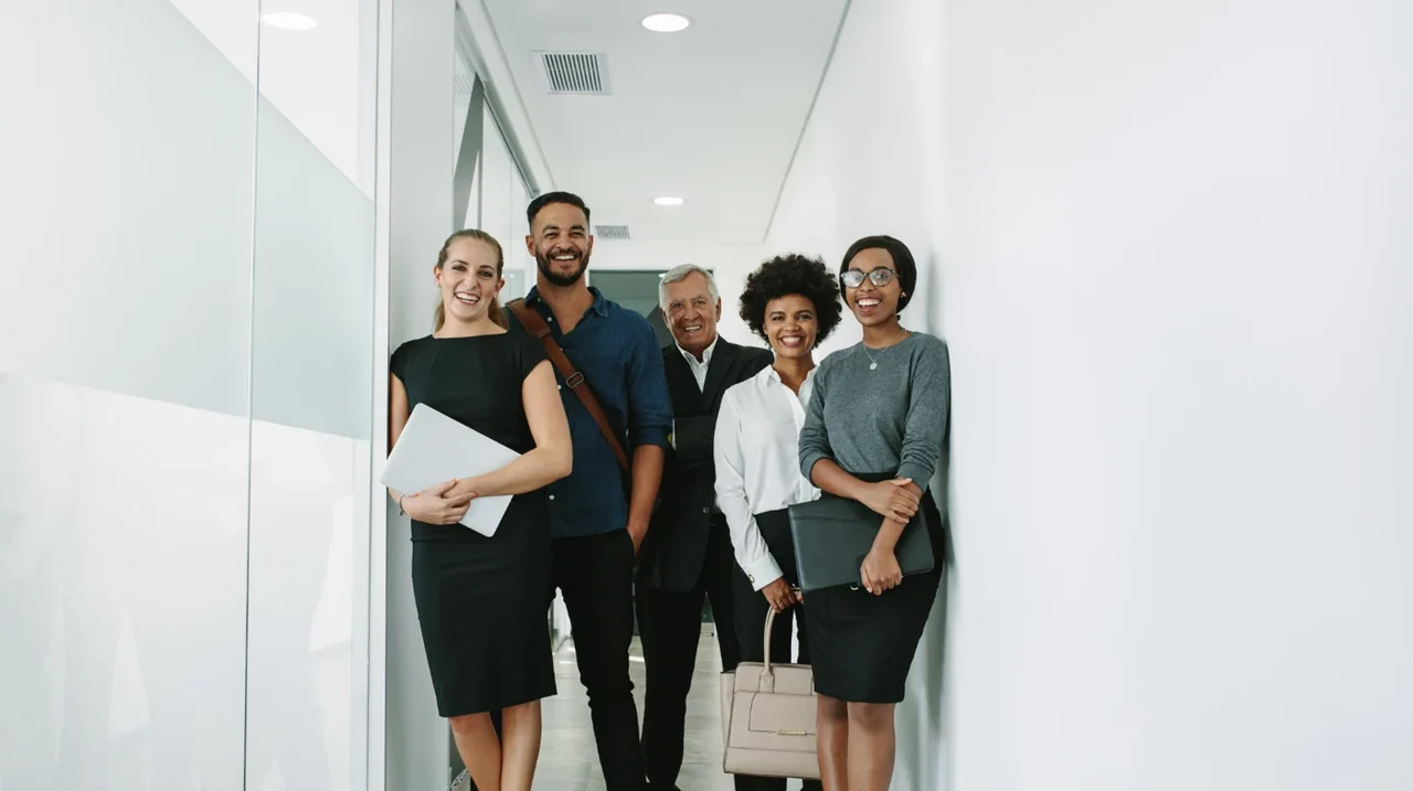 A group of colleagues standing together in an office.