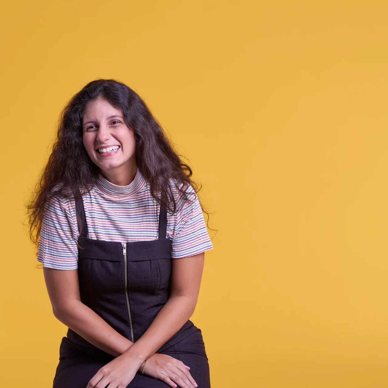 Smiling student against a golden yellow background.