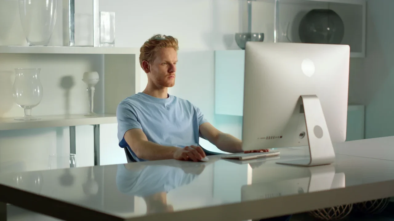 Professional concentrating at a desktop computer.