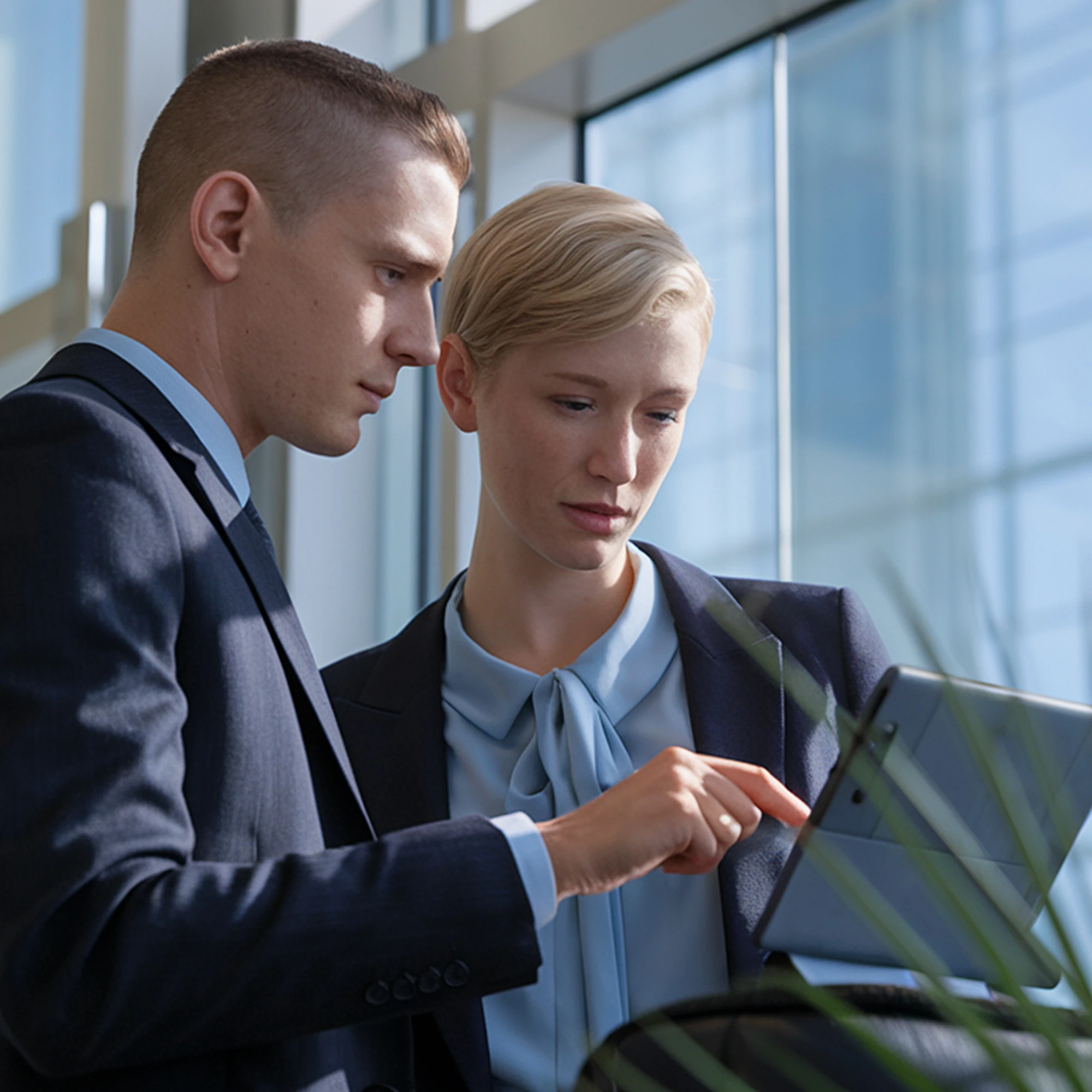 Two colleagues reviewing a tablet together.