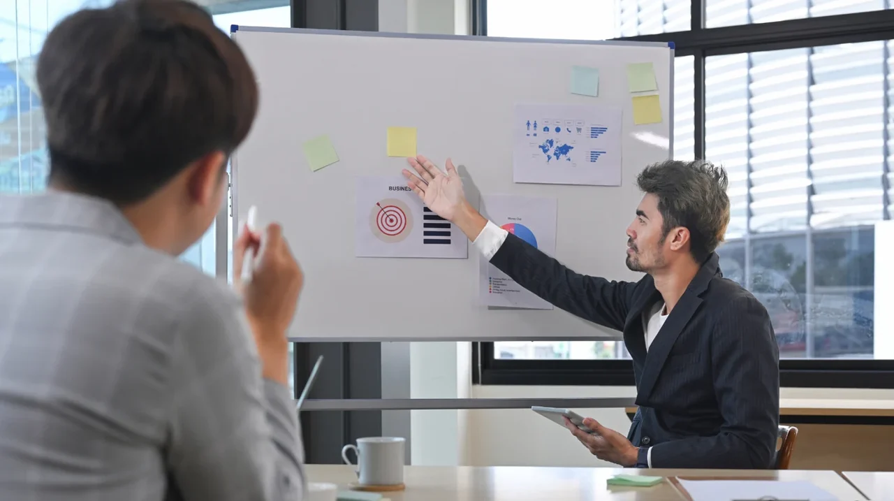 Colleagues discussing a plan on a presentation screen.