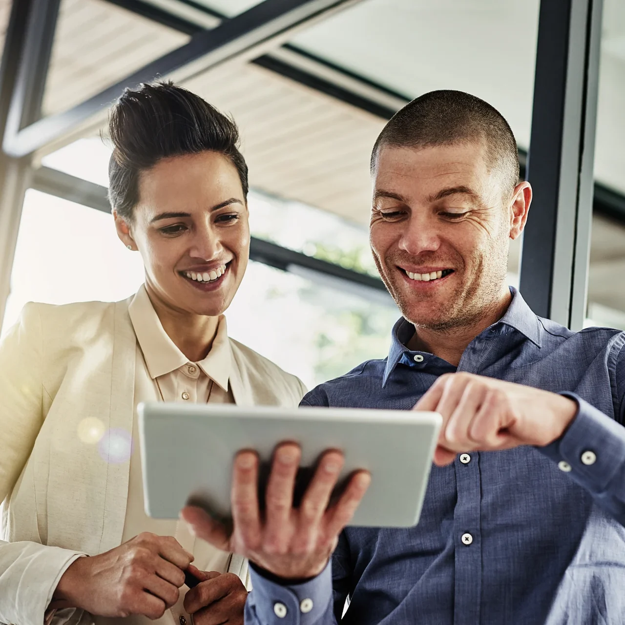 Two colleagues reviewing a tablet together.