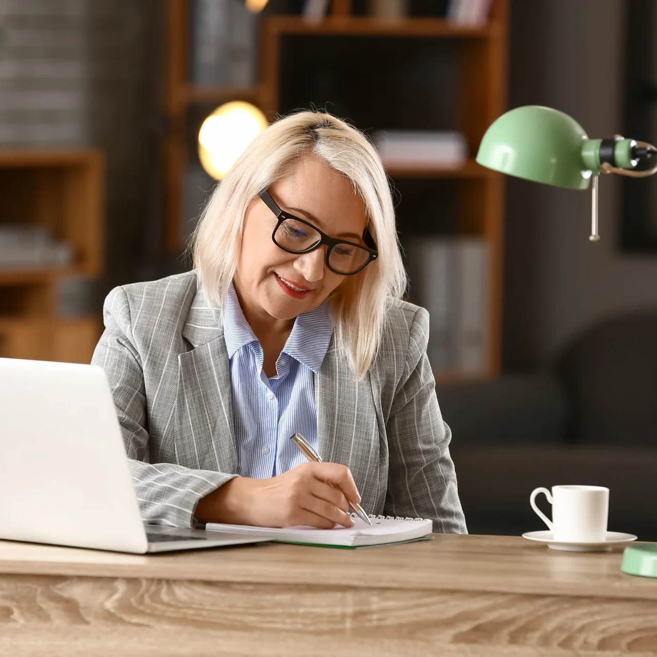 Professional writing notes beside a laptop.