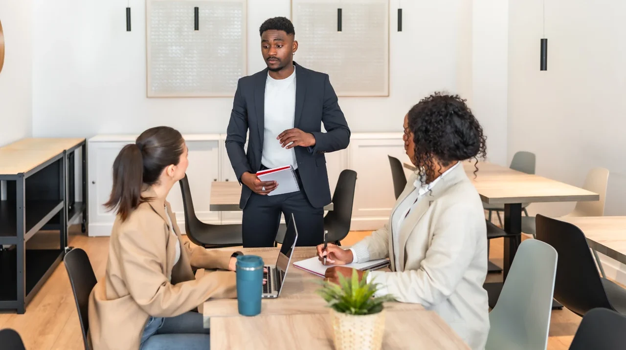 Professional presenting to seated colleagues.