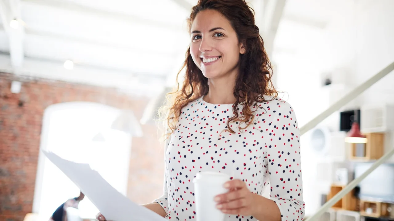 Professional holding notes in a bright workplace.