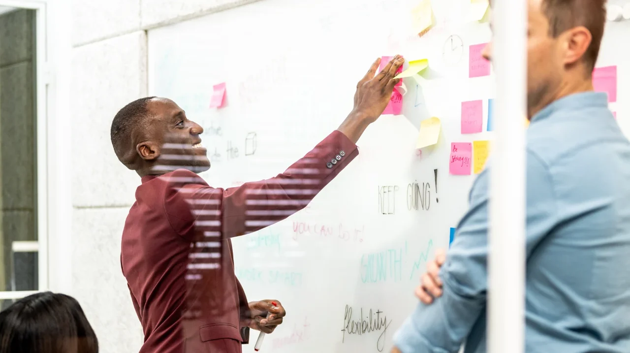Professional arranging sticky notes on a planning wall.