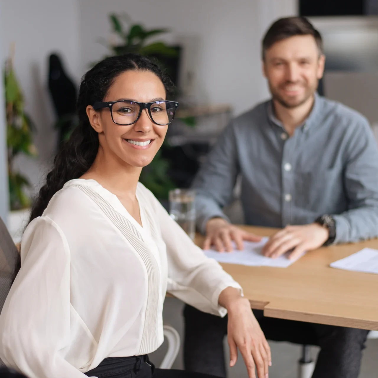 Professional smiling at a meeting table.