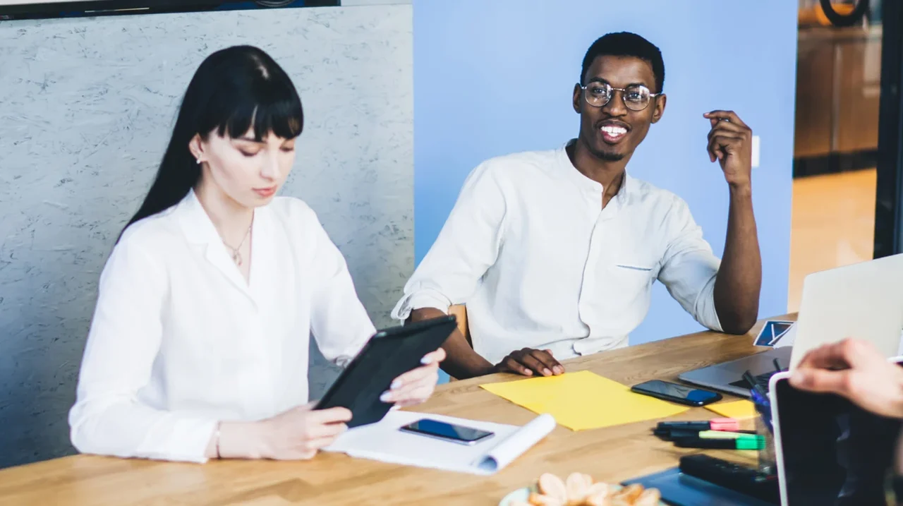 Coworkers discussing notes around a table.
