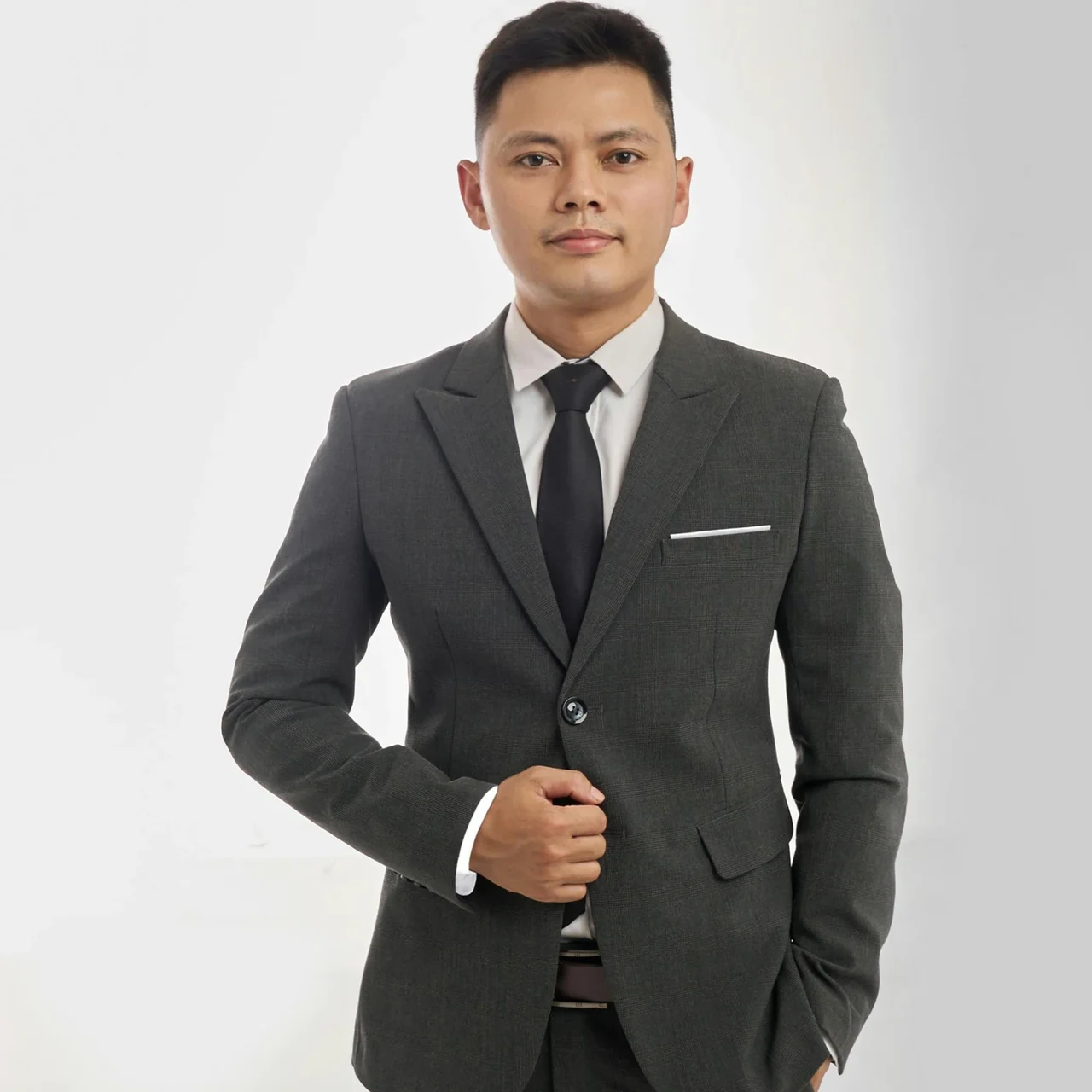 Professional in a dark suit against a neutral background.