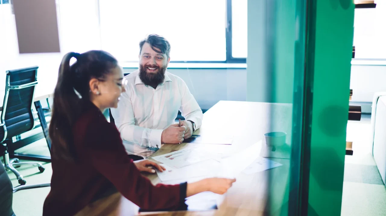 Two colleagues smiling during a conversation.