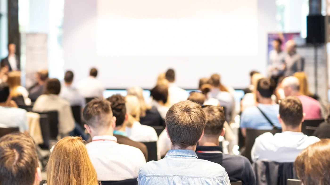 Attendees listening to a presentation in a training room.