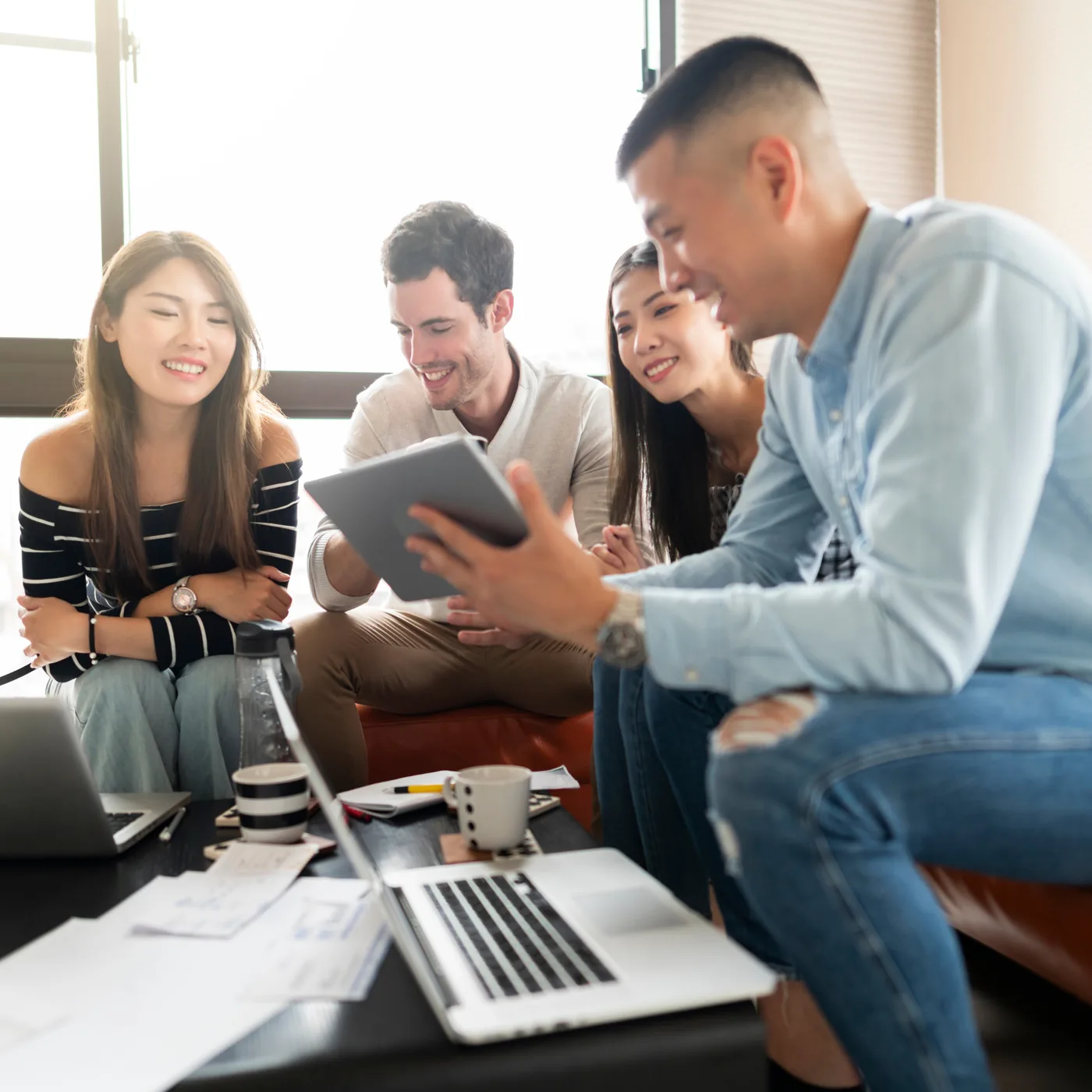 Early-career cybersecurity professionals collaborating with tablets during a group learning session
